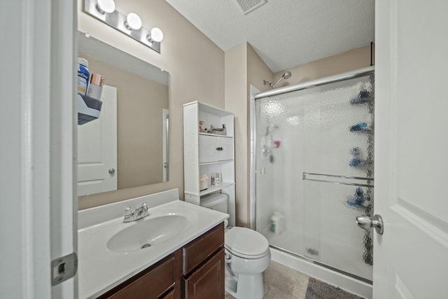 full bath featuring visible vents, toilet, a stall shower, a textured ceiling, and vanity