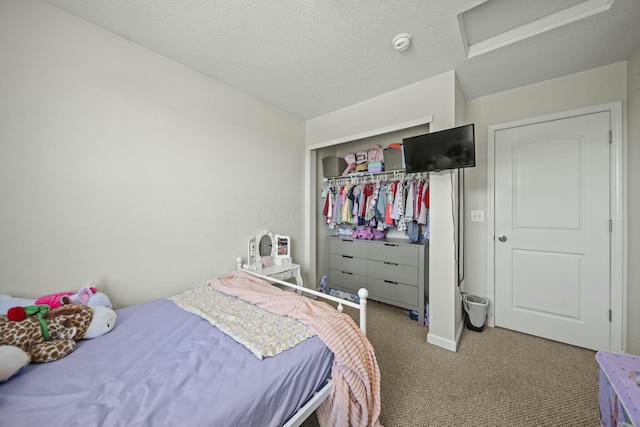 carpeted bedroom featuring a textured ceiling and attic access