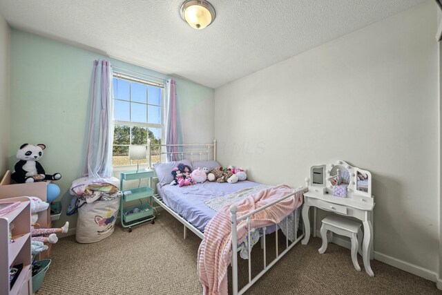 carpeted bedroom featuring baseboards and a textured ceiling