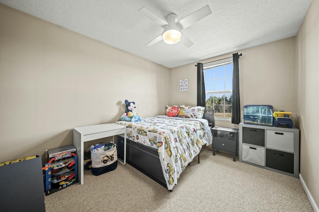 carpeted bedroom featuring a ceiling fan and a textured ceiling