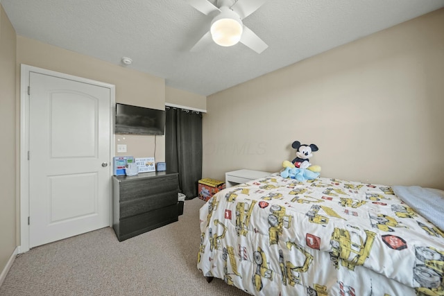 carpeted bedroom with a ceiling fan and a textured ceiling