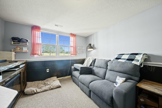 carpeted living room featuring visible vents and a textured ceiling