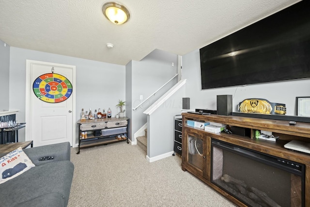 living room with carpet flooring, baseboards, a textured ceiling, and stairs