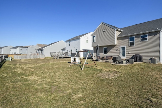 rear view of property featuring fence, a yard, a playground, a patio area, and a residential view