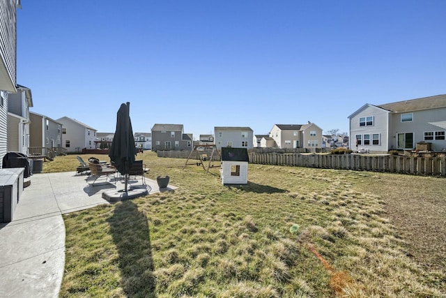 view of yard featuring a patio area, a residential view, and fence