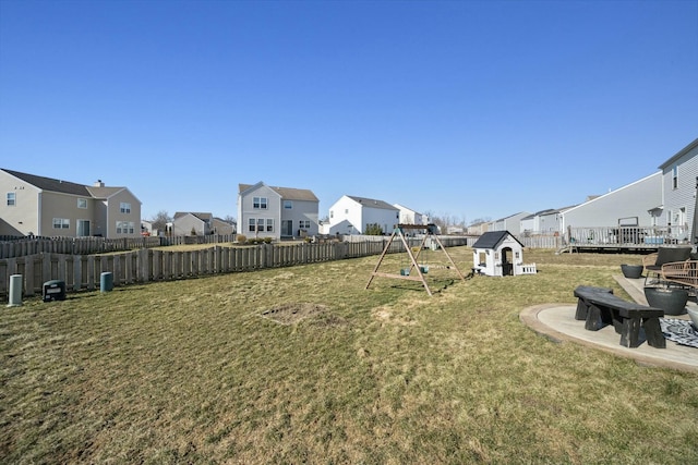 view of yard with a playground, fence, and a residential view