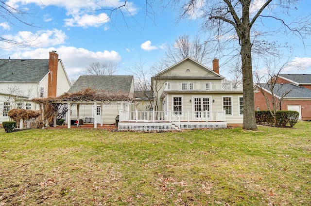 back of house featuring a deck, a yard, and a chimney