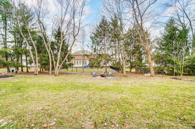 view of yard featuring an outdoor fire pit and fence