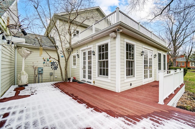 snow covered deck with french doors