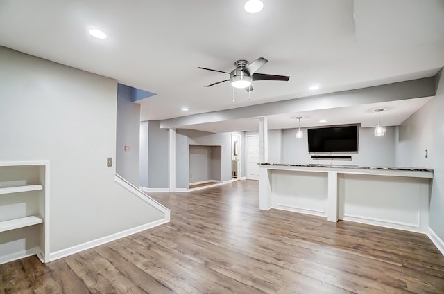 kitchen featuring a ceiling fan, baseboards, and wood finished floors