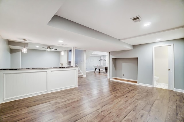 interior space with visible vents, ceiling fan, wood finished floors, baseboards, and stairs