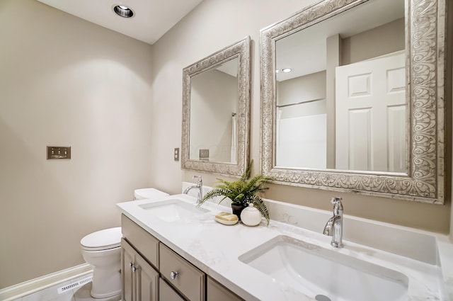 full bathroom with visible vents, double vanity, a sink, and toilet