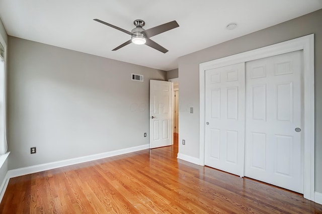 unfurnished bedroom featuring light wood-style floors, a closet, visible vents, and baseboards