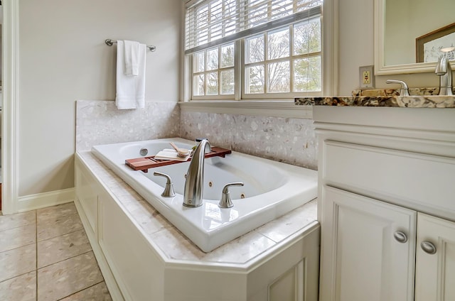 bathroom with tile patterned flooring, baseboards, vanity, and a tub with jets