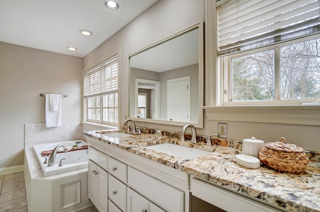 bathroom featuring double vanity, a tub with jets, a sink, and recessed lighting