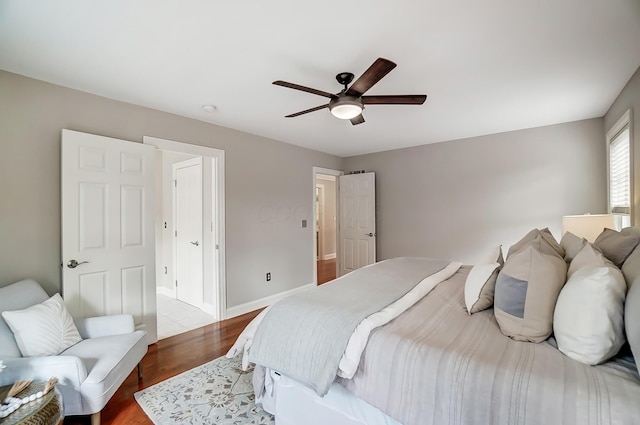 bedroom with a ceiling fan, baseboards, and wood finished floors