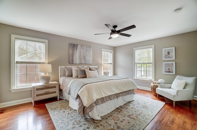 bedroom featuring ceiling fan, baseboards, and wood finished floors