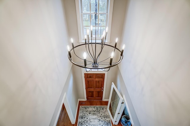 entryway featuring a high ceiling, an inviting chandelier, and baseboards