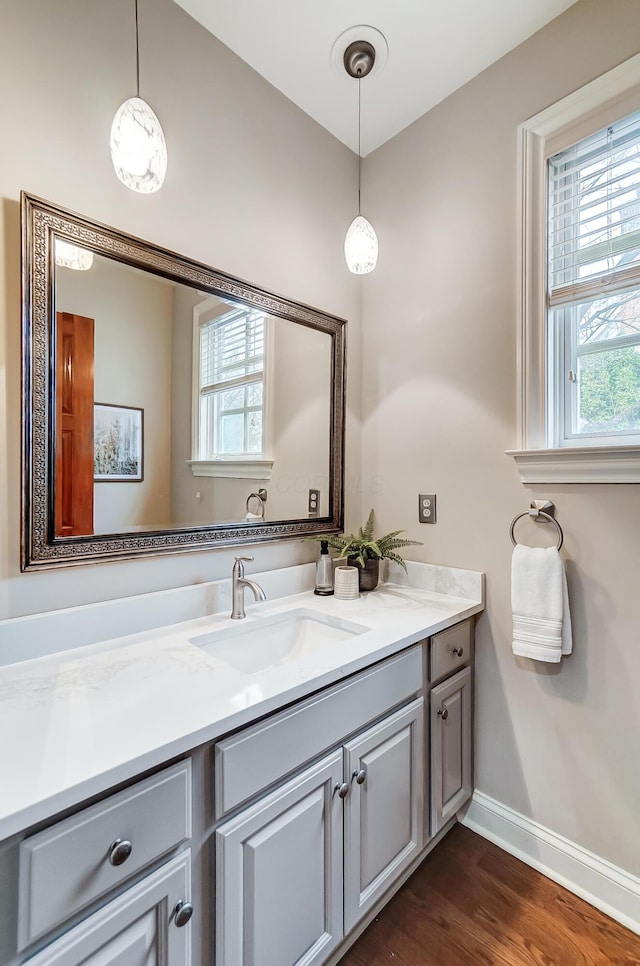 bathroom with vanity, baseboards, and wood finished floors