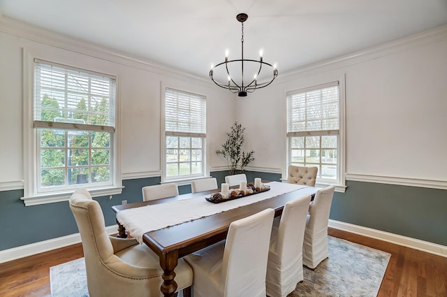 dining area featuring a notable chandelier, plenty of natural light, and wood finished floors