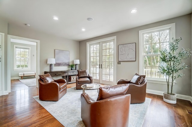 sitting room featuring a healthy amount of sunlight, wood finished floors, and french doors