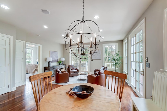 dining area featuring a chandelier, baseboards, wood finished floors, and recessed lighting