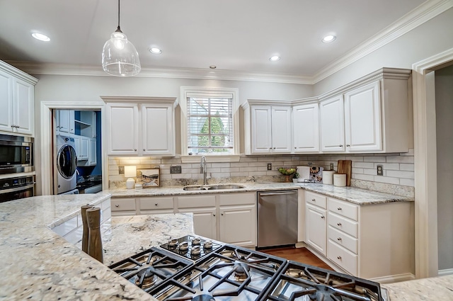 kitchen with crown molding, stainless steel appliances, washer / clothes dryer, white cabinets, and a sink