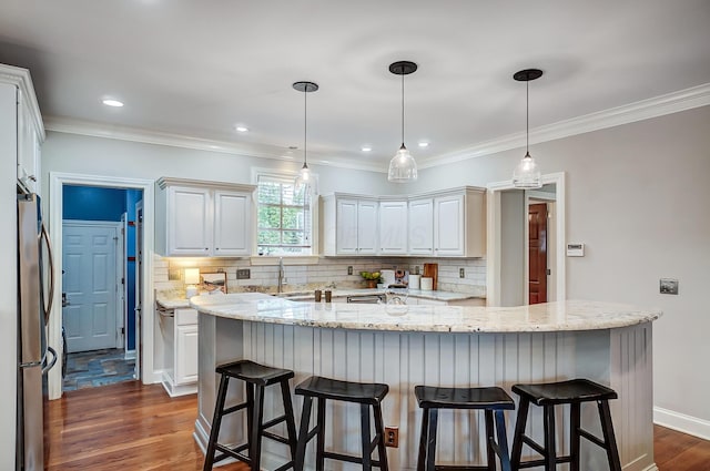 kitchen with backsplash, dark wood-style flooring, freestanding refrigerator, crown molding, and a sink