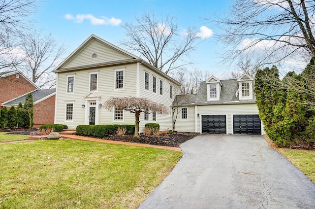 view of front of house with driveway and a front lawn