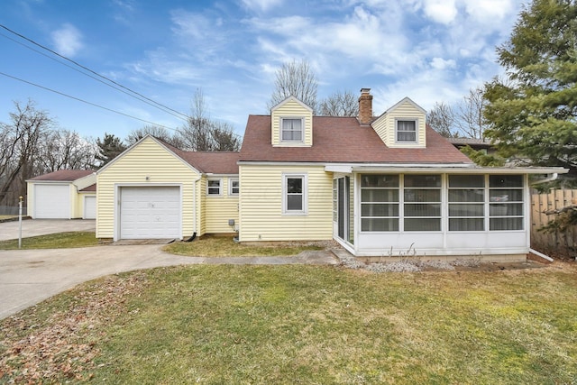 view of front facade with an outbuilding, an attached garage, a sunroom, a chimney, and a front yard