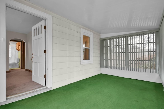 unfurnished sunroom with arched walkways and plenty of natural light