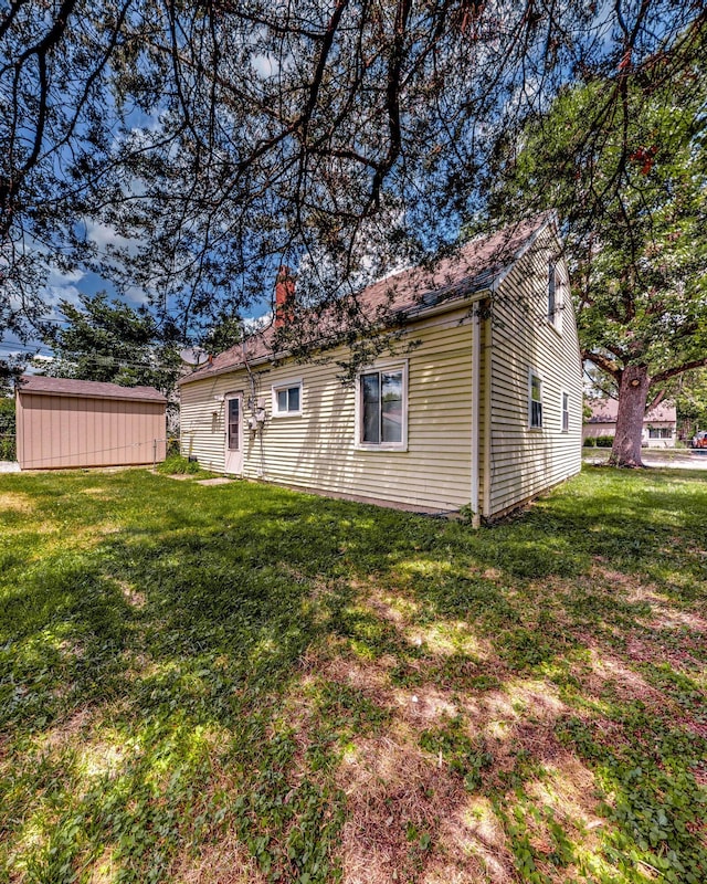 exterior space with a yard, an outdoor structure, and a chimney