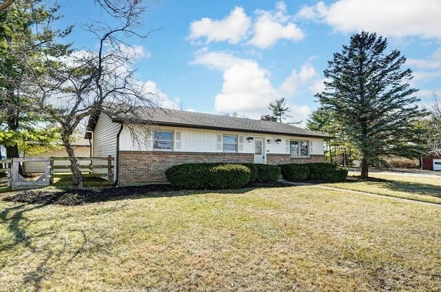 single story home with a front yard, fence, and brick siding