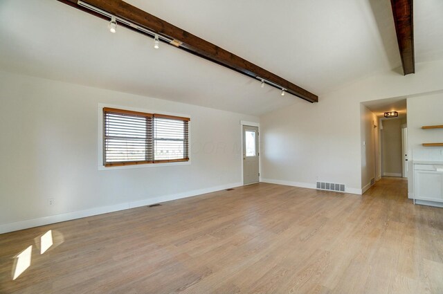 spare room with visible vents, vaulted ceiling with beams, light wood-type flooring, and baseboards