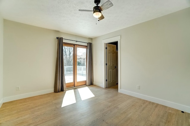 unfurnished room featuring ceiling fan, a textured ceiling, light wood-type flooring, and baseboards