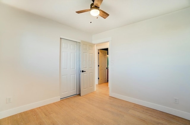 spare room featuring baseboards, light wood-style flooring, and a ceiling fan