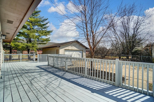 deck with a garage, an outbuilding, and fence