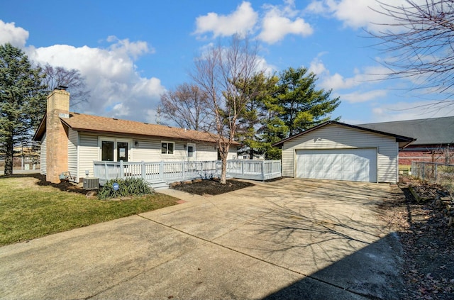 view of side of property featuring an outbuilding, a lawn, a deck, a garage, and a chimney