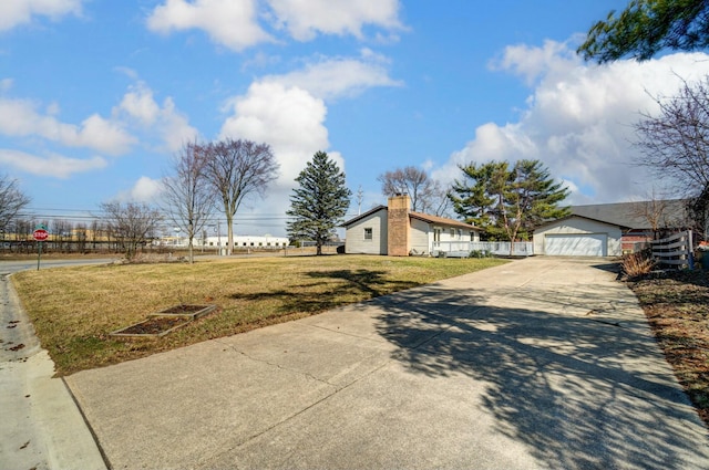 view of yard with an outdoor structure, fence, and a garage