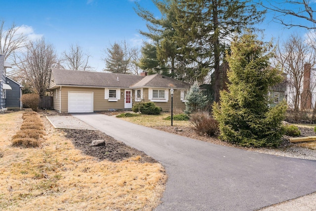 ranch-style home featuring aphalt driveway and an attached garage