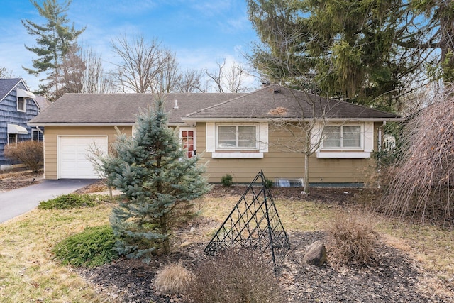 view of front of house with driveway, an attached garage, and a shingled roof