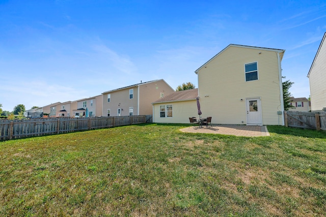 rear view of property with a fenced backyard, a patio, and a lawn