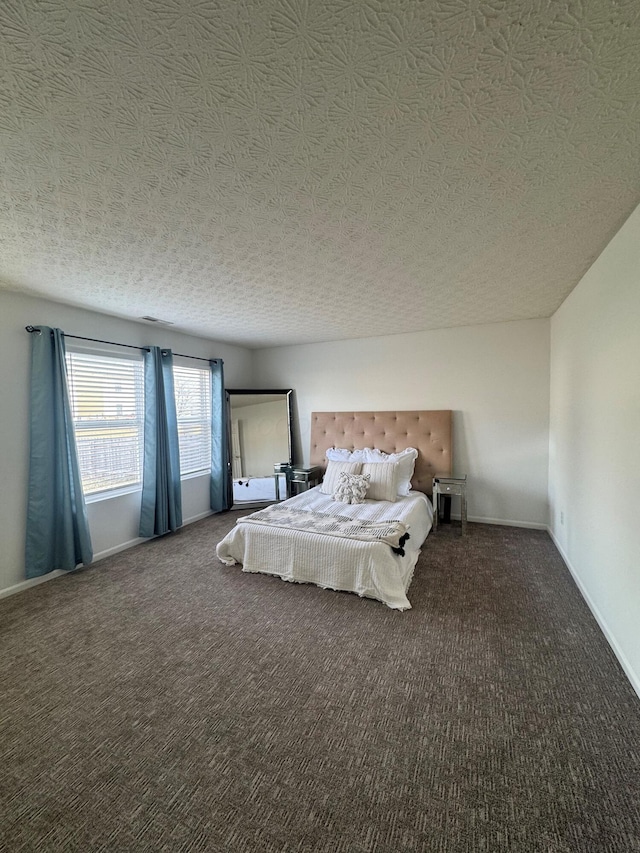 unfurnished bedroom with a textured ceiling, carpet flooring, and baseboards