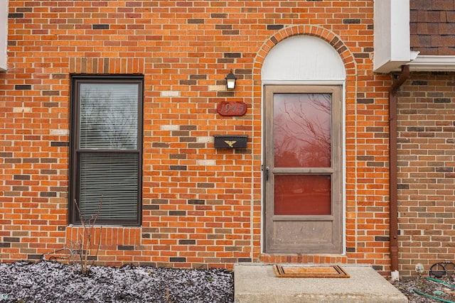 doorway to property with brick siding