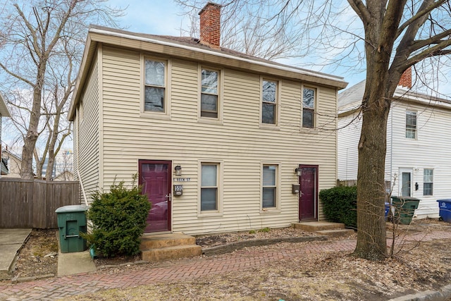 view of front of property featuring a chimney and fence