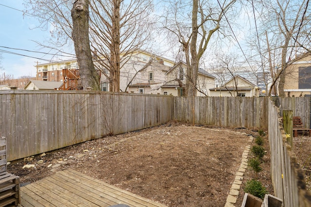 view of yard featuring a residential view, a fenced backyard, and a deck