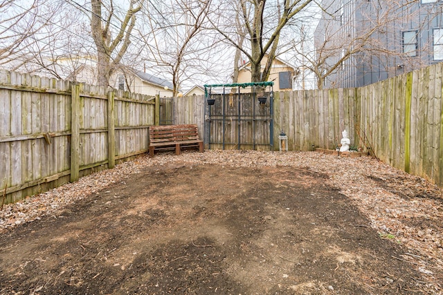 view of yard with a fenced backyard and a gate