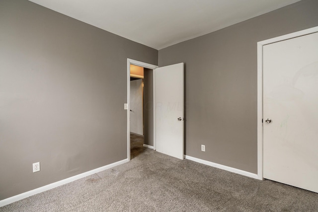 unfurnished bedroom featuring carpet flooring and baseboards