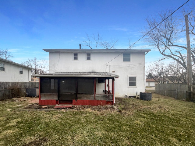 rear view of house with a sunroom, fence, metal roof, and a lawn