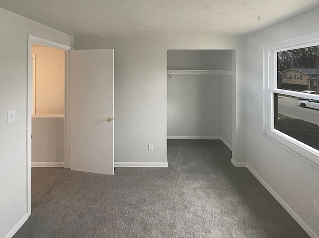 unfurnished bedroom featuring a closet, baseboards, and carpet flooring